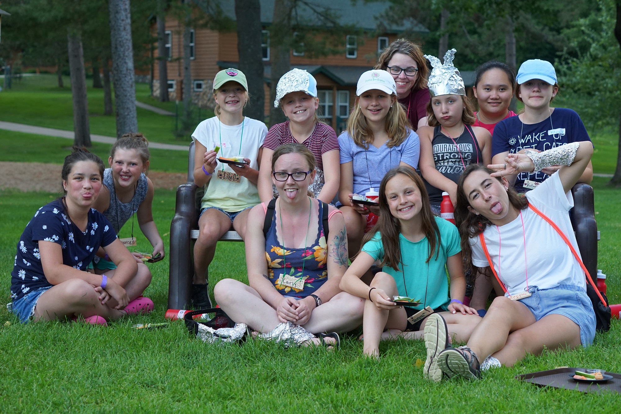 Group of female campers and cabin counselors sticking out their tongues