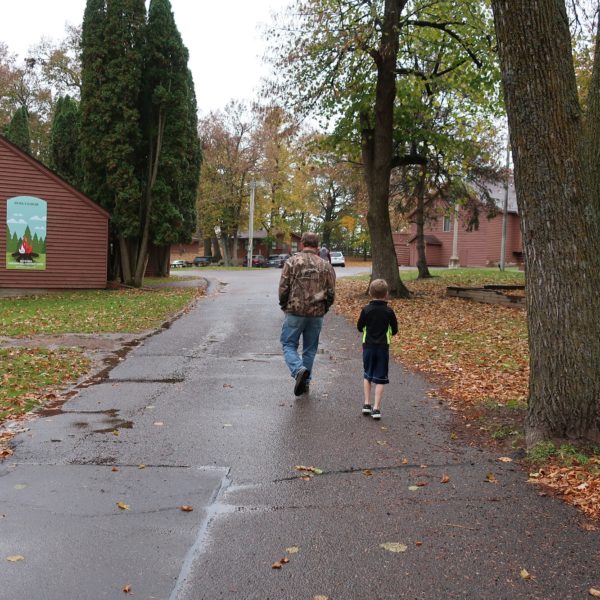 Dad and son walking on path in the fall