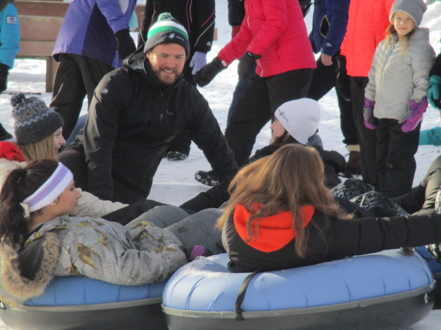 youth on winter tubes getting ready to go down the sledding hill