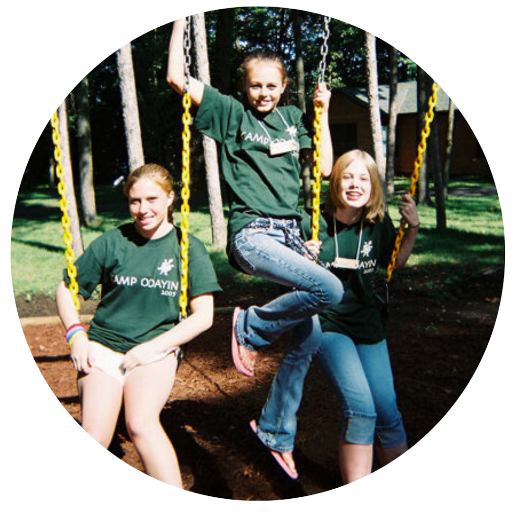 Three campers on a swing set in 2005 camp t-shirts