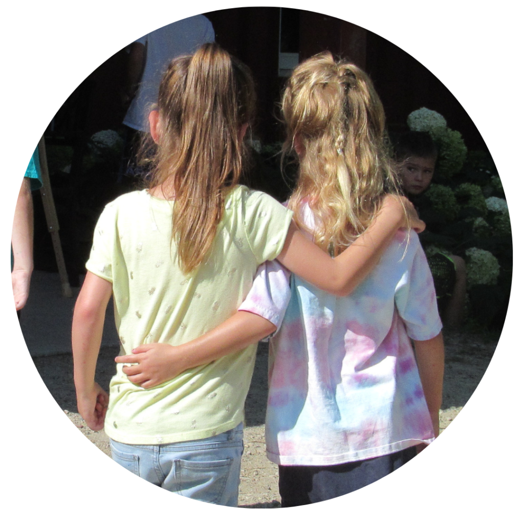 View of two small friends' backs with arms around each other 