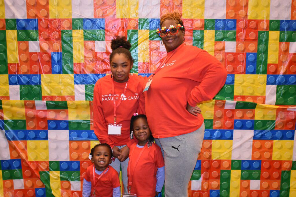 A family smiles for a photo at the Lego-themed photobooth