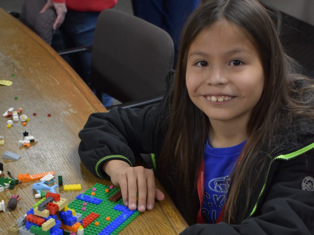 Smiling camper building with Lego at Family Camp