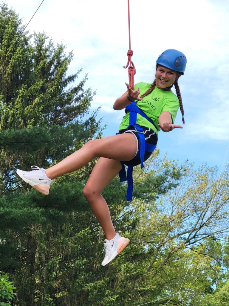Happy camper hanging from rope course