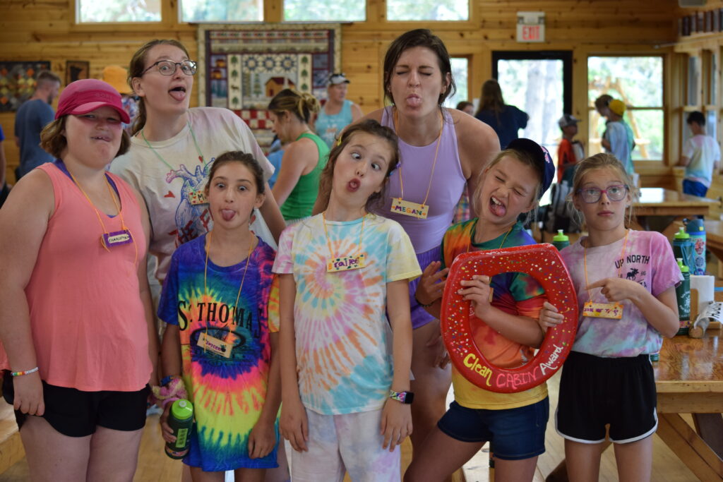 A group of campers and volunteers holding a painted toilet seat - the clean cabin award.