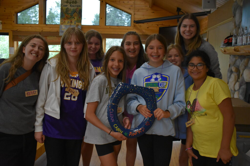Group of campers holding painted toilet seat, the 'clean cabin award'