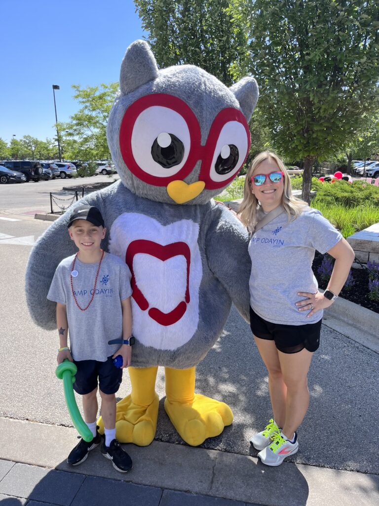 Two Odayin volunteers standing with a CHD owl mascot