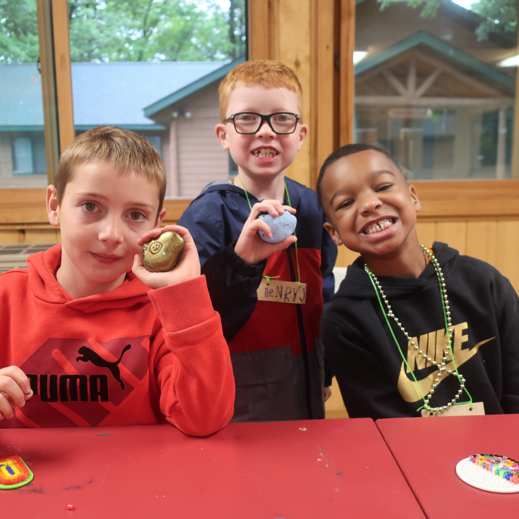 Three campers holding painted rocks