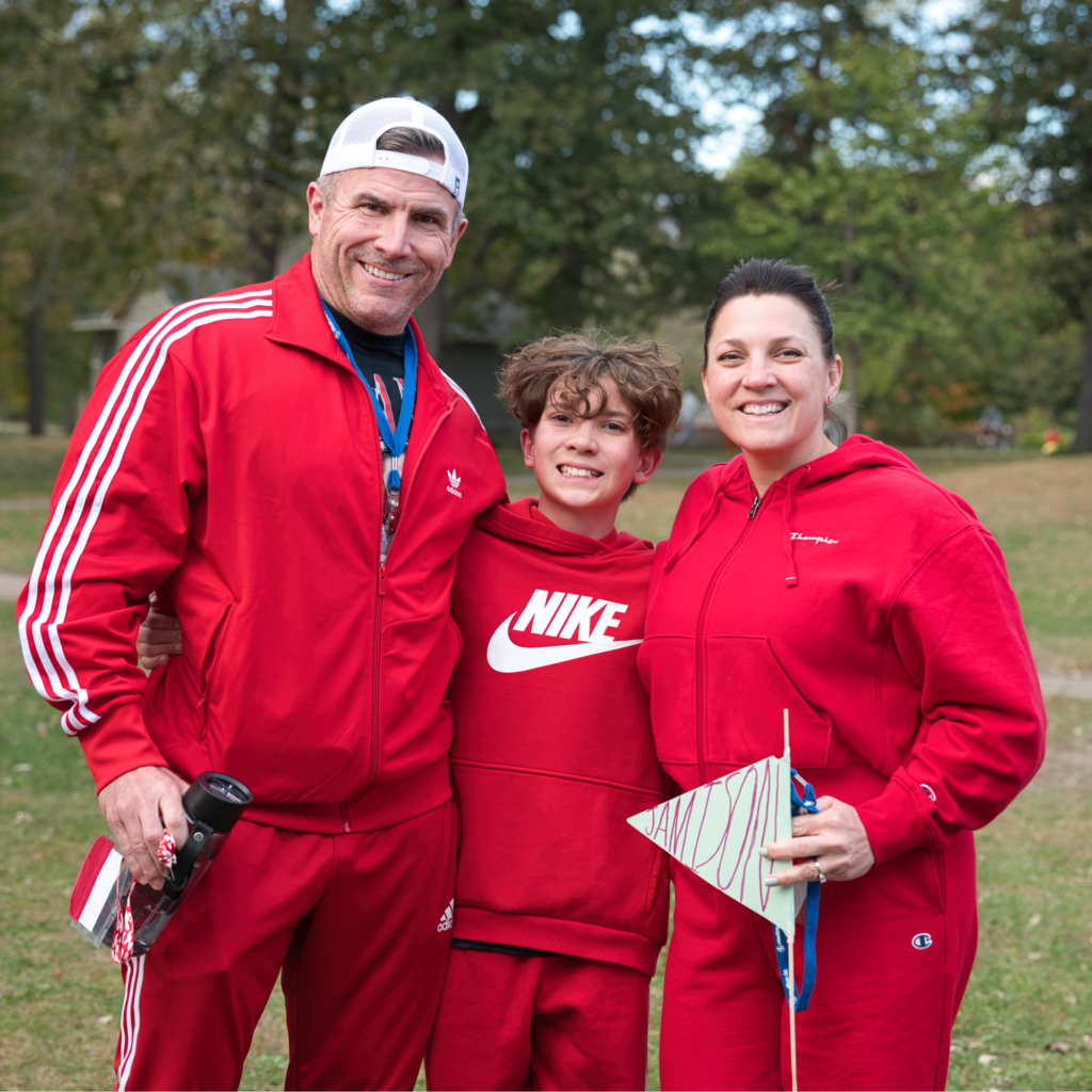 Three family members wearing red standing together